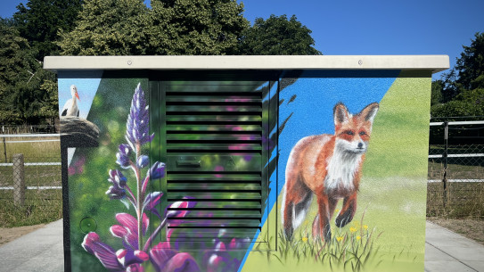Graffiti-Malerei auf einem Verteilerkasten mit einem Fuchs, Blumen und einem Storch.