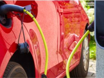 Roter Elektroautoladestationen mit gelben Ladekabeln an der Ladesäule.