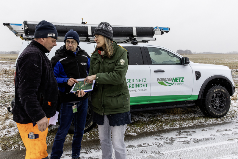 Heiko Haase von der Elektro- und Energieanlagenbau (EEB) GmbH, Mario Hiersemann von der WEMAG Netz und Ulrike Hagemann von der Biosphärenreservatsverwaltung Niedersächsische Elbtalaue (v. l.) besprechen den genauen Standort für den Ausweichmast. Foto: WEMAG/Stephan Rudolph-Kramer