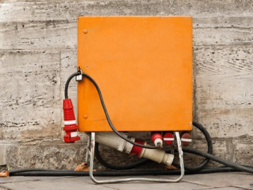 Orangener Baustromkasten mit Kabeln