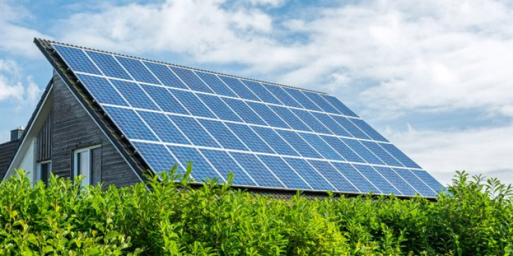 Photovoltaikanlage auf Einfamilienhausdach mit grünen Sträuchern