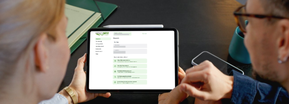 Eine Frau und ein Mann schauen sich das Kunden-Self-Service-Portal auf einem Tablet an. 